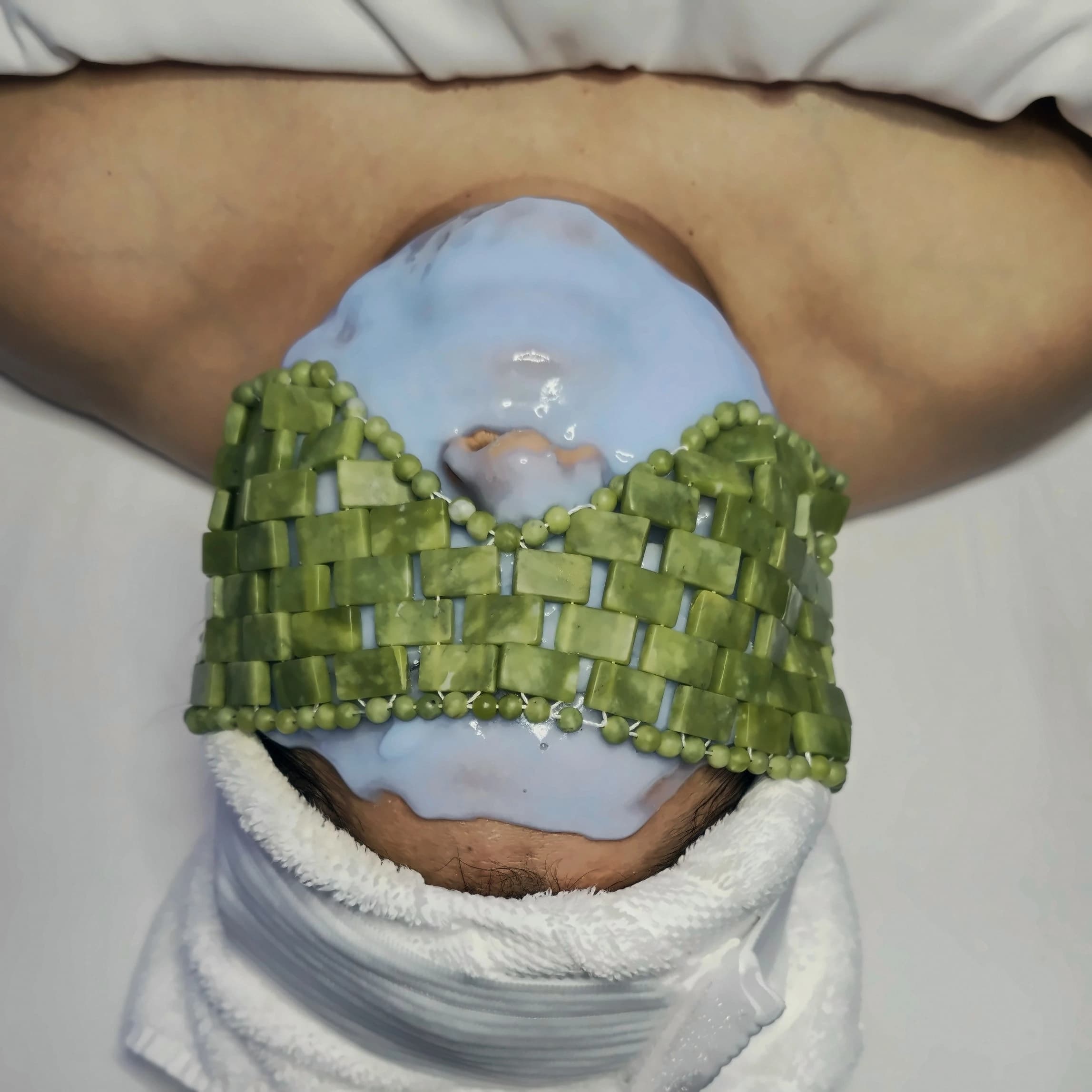 A facial mask with jade stones during a treatment at Essence